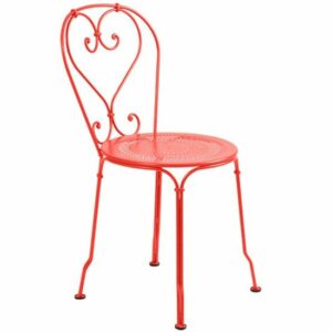 Red metal side chair with heart-shaped back. Decorative, vintage-style furniture. Ideal for patio or garden.