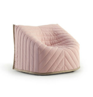 Upholstered Talo Armchair in pink fabric. Lounge chair with a geometric, quilted pattern and wood frame.