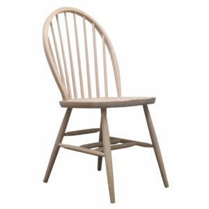 Angled view of a light wood Easter side chair with a spindle back. The frame is wood and the seat can be upholstered.