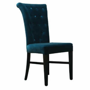 Angled view of a blue velvet Kemp side chair with a button-tufted back and dark wood frame.