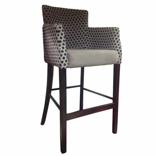 Upholstered Mega barstool with arms. The seat is light gray and the back and arms have a black and white polka dot pattern. Dark stained wood frame.