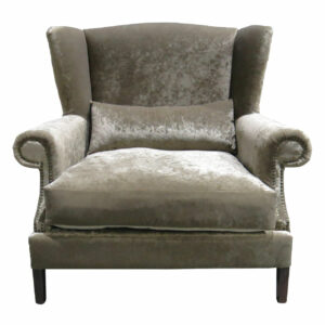 Front view of a velvet Royal lounge chair. Wingback design with rolled arms, nailhead trim, and lumbar pillow. Solid wood frame.