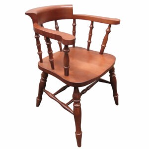 Angled view of a stained wood Smoke Armchair. The chair has a curved back, armrests, and spindle details.