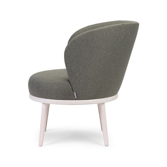 Side view of the Audrey lounge chair in muted green upholstery, showcasing its rounded seat, curved back, and light-colored solid beech frame.