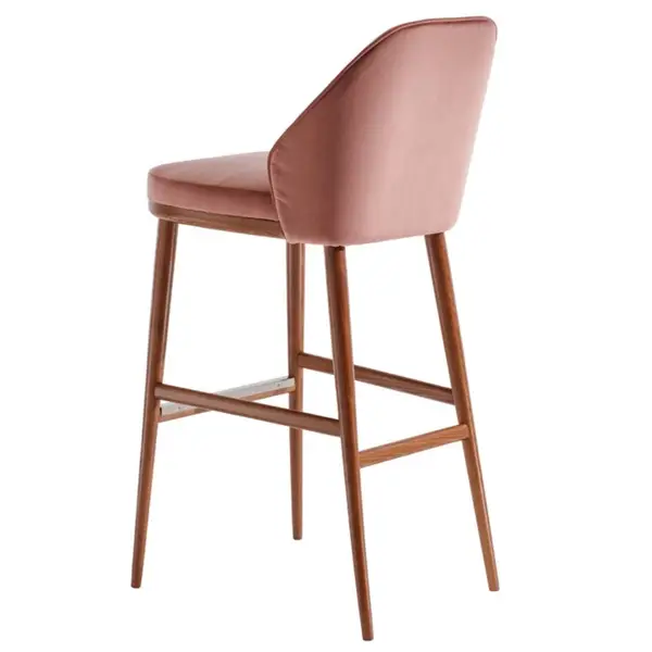 Rear view of a pink velvet Rise Barstool featuring a sleek wooden four-legged frame and elegant curved backrest.