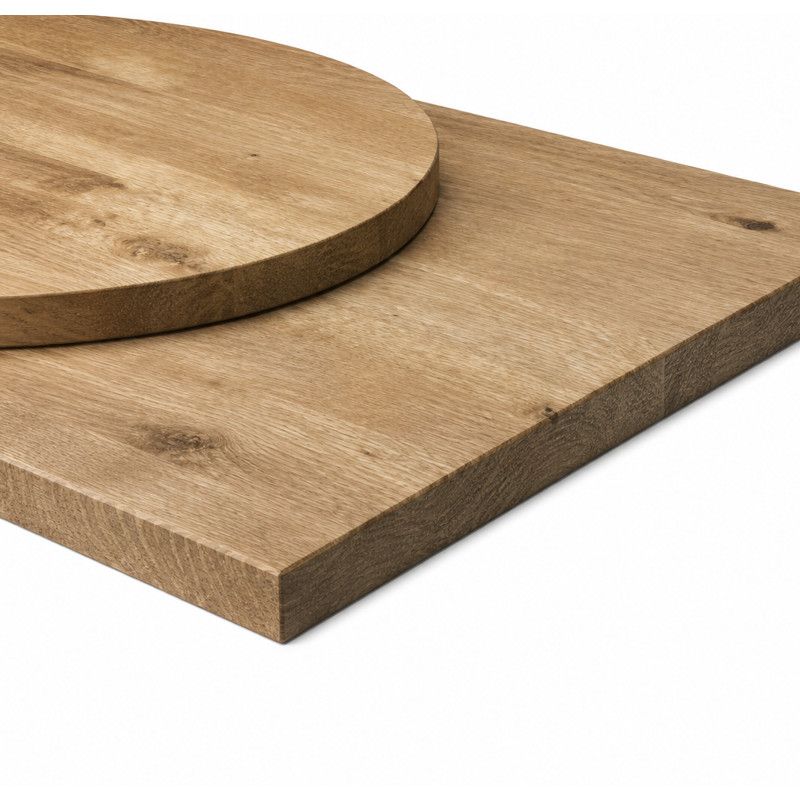 Top-down perspective of a round wood rustic antique oak table top resting on a flat, rectangular wooden board.