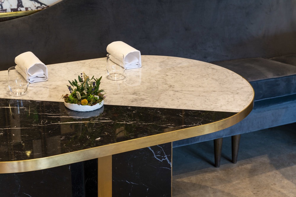 Restaurant Story London table setting. Marble table, glassware, napkins, floral arrangement.