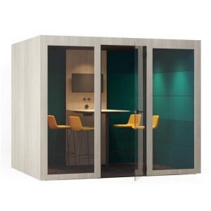 Wood-framed Silent Room L with upholstered walls and glass door. Interior view with table and yellow chairs.