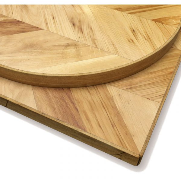 Close-up of a light brown wood fishbone table top, featuring a square and semi-circle shape.