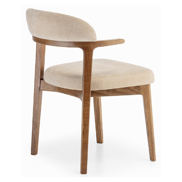 Angled view of the Yuma armchair. It has a wooden frame and is upholstered in a light beige fabric.