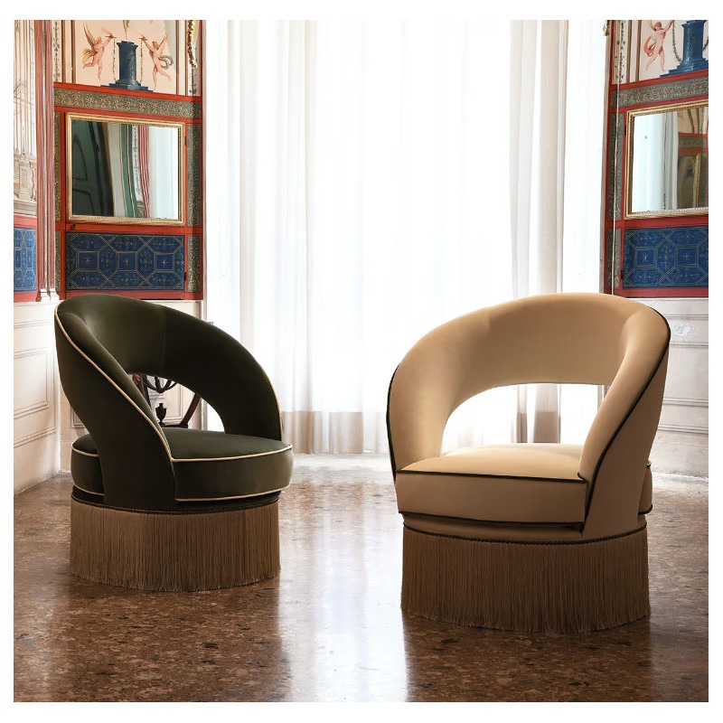 Two Dione Lite lounge chairs, one green and one beige, with fringe detail, in an ornate room.