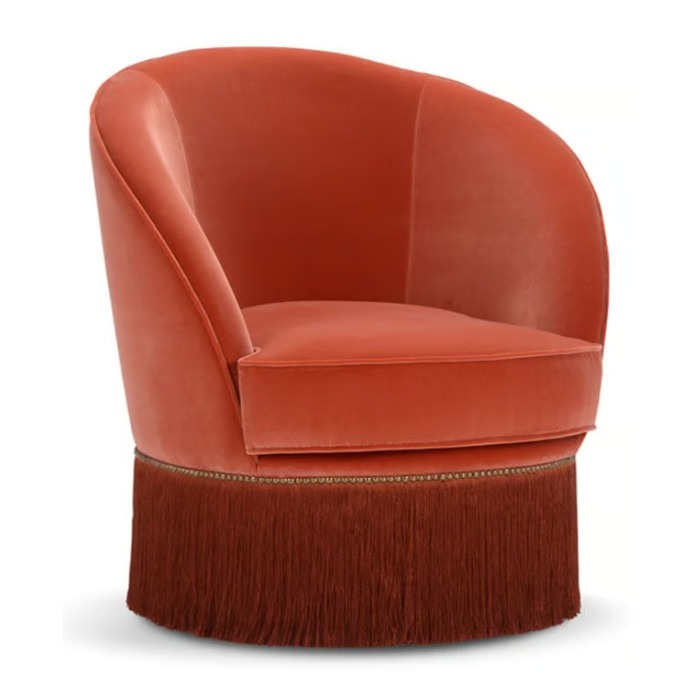 Upholstered Dione lounge chair in orange. Features a rounded back, cushioned seat, and stylish fringe detail.