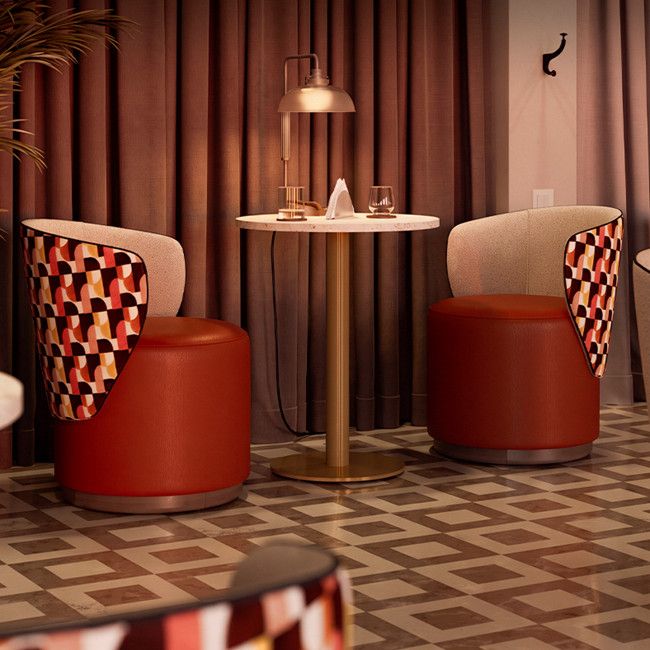 Yana pouf with vibrant geometric patterned back and solid red upholstery, rounded wooden base.