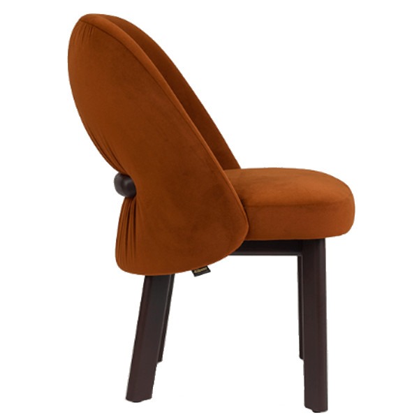 Side view of a rust-colored upholstered Cintura side chair. The chair has a wooden frame and a unique back design.