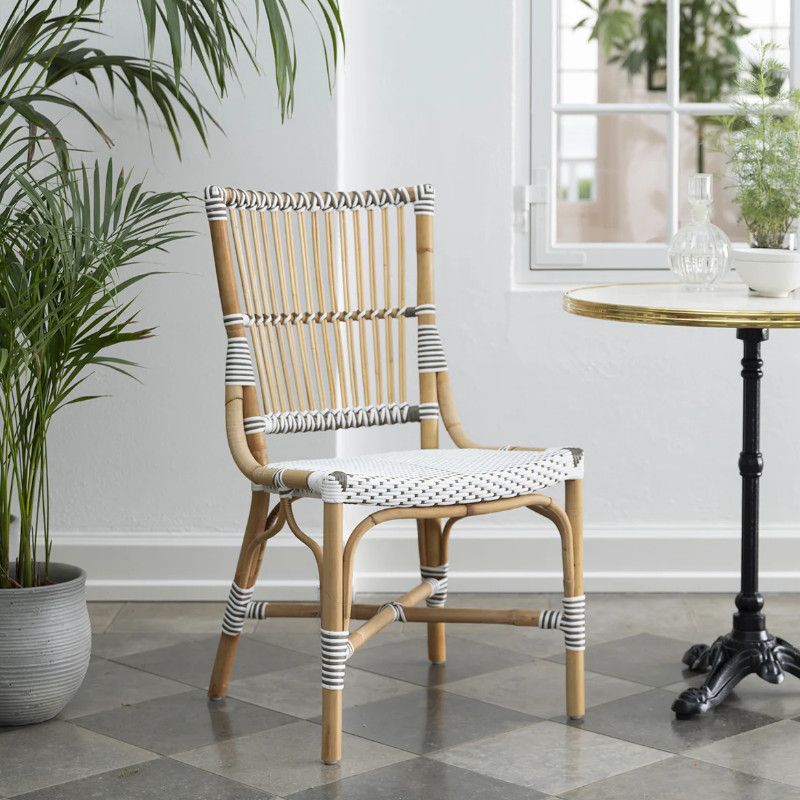 Metal-framed Monique armchair with woven cane back and seat pad. Accented with black and white striped detail.