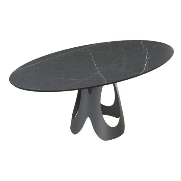 Angled view of the Olive oval dining table. It has a dark metal base and a dark, marble-patterned HPL laminate top.