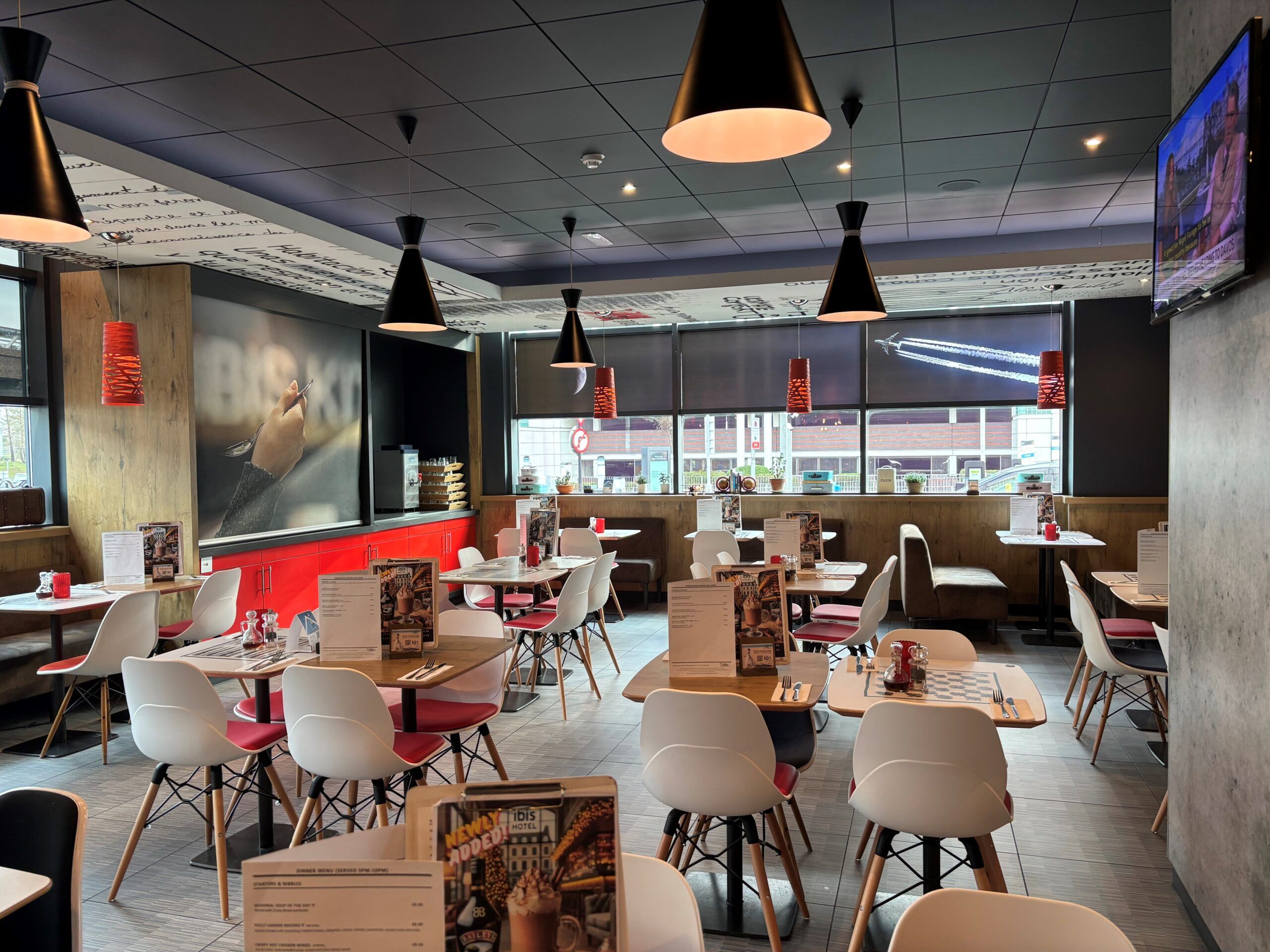 Ibis Hotel Birmingham restaurant interior. Tables, chairs, and modern lighting.