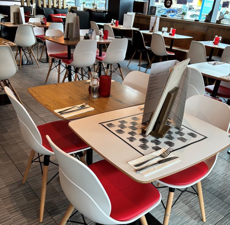 Ibis Hotel Birmingham restaurant interior. Tables, chairs, and menus create a welcoming dining space.