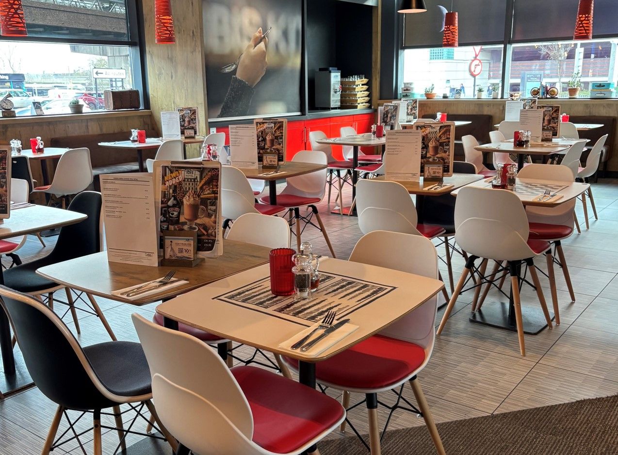 Ibis Hotel Birmingham restaurant interior. Tables, chairs, menus, and decor create a welcoming dining space.