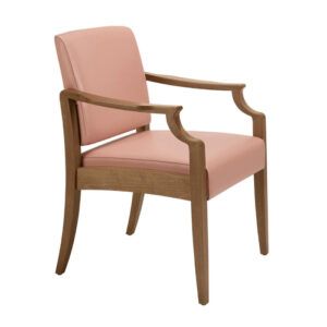Angled view of the Janelle armchair. It has a wooden frame and light pink upholstered seat and back.