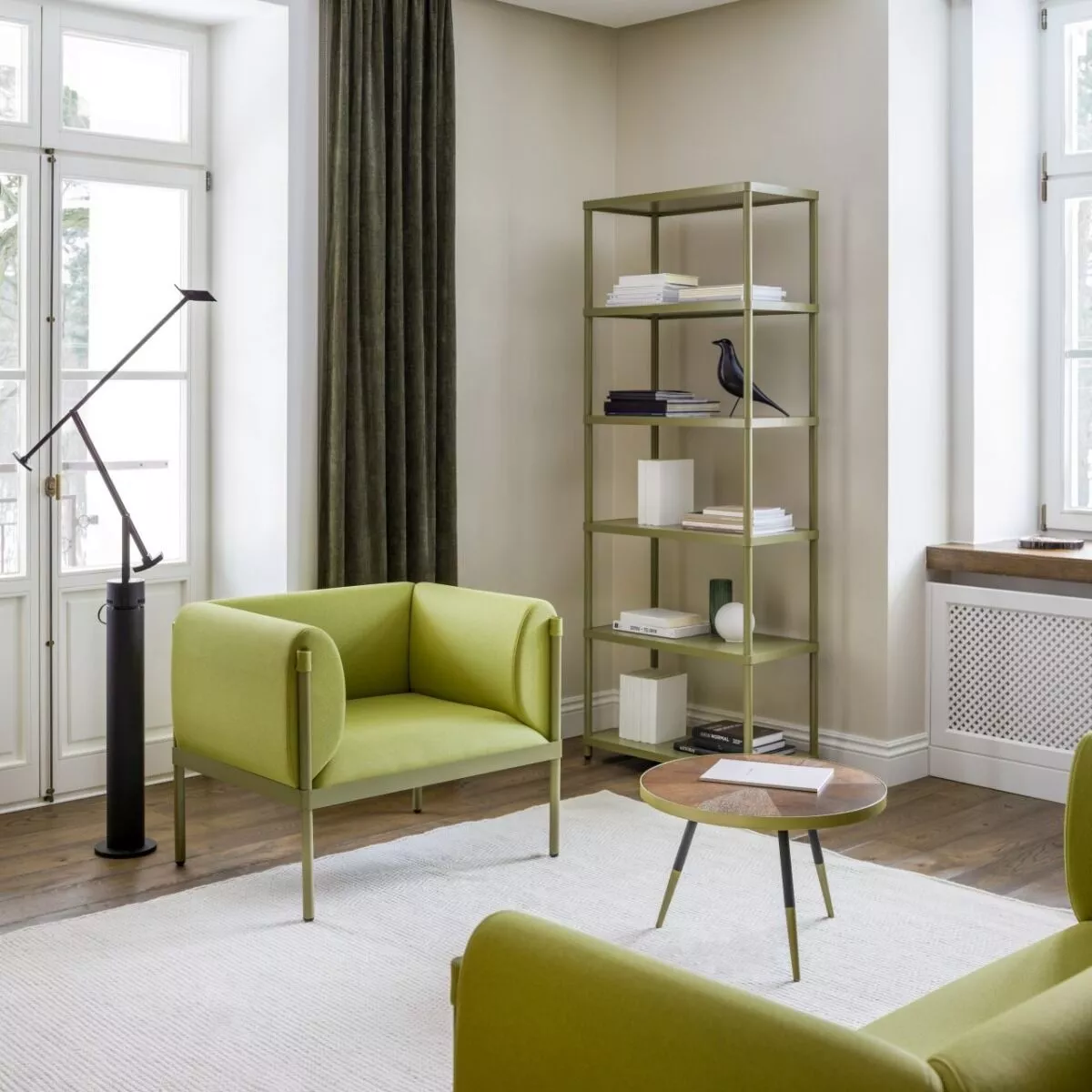 Upholstered Stilt armchair in light green with a metal frame, in a living room setting.