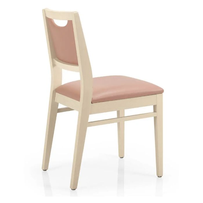 Back view of Bety side chair featuring a solid beech frame, upholstered in a light pink fabric. Handle detail at the back.