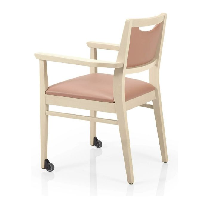 Rear view of Bety W Armchair with cream wood frame, light pink upholstered seat and back, and mobility wheels on front legs.