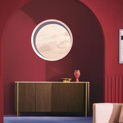 Blume 4 Sideboard with walnut doors placed against a deep red arched wall featuring a round window and minimalist decor.