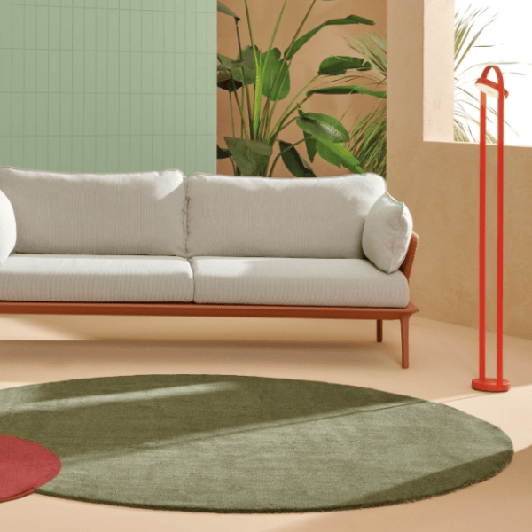 Giravolta 1799T130 Floor Lamp: A minimalist red LED floor lamp in a modern living room setting with sofa and olive rug.