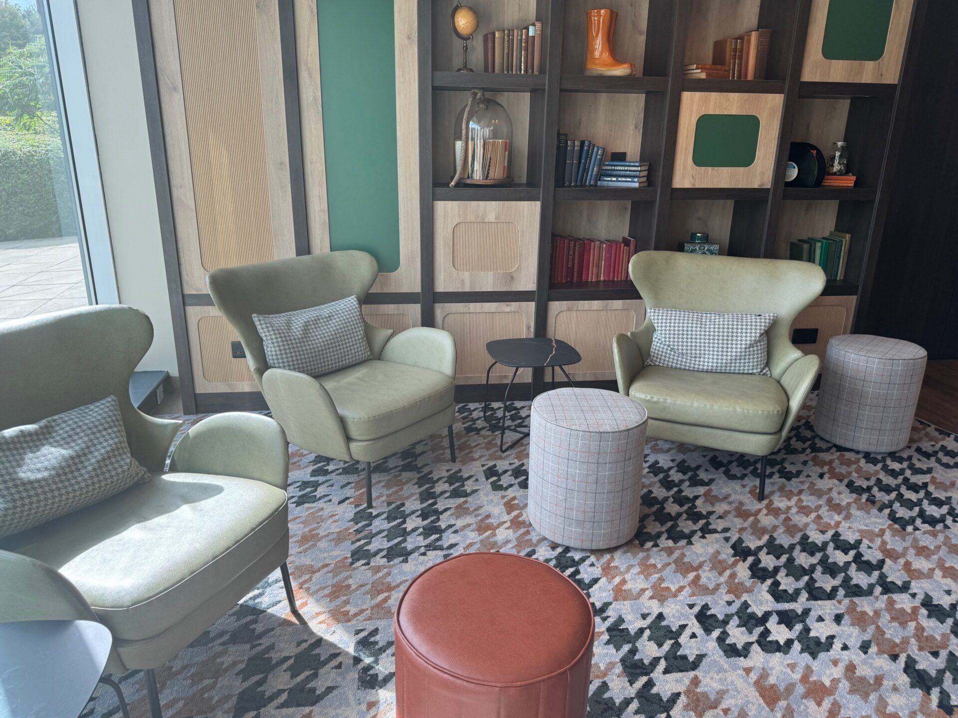 B&B Hotel Warrington B&B Hotel Warrington seating area with armchairs, footstools, and bookshelf. Modern hotel lobby design.