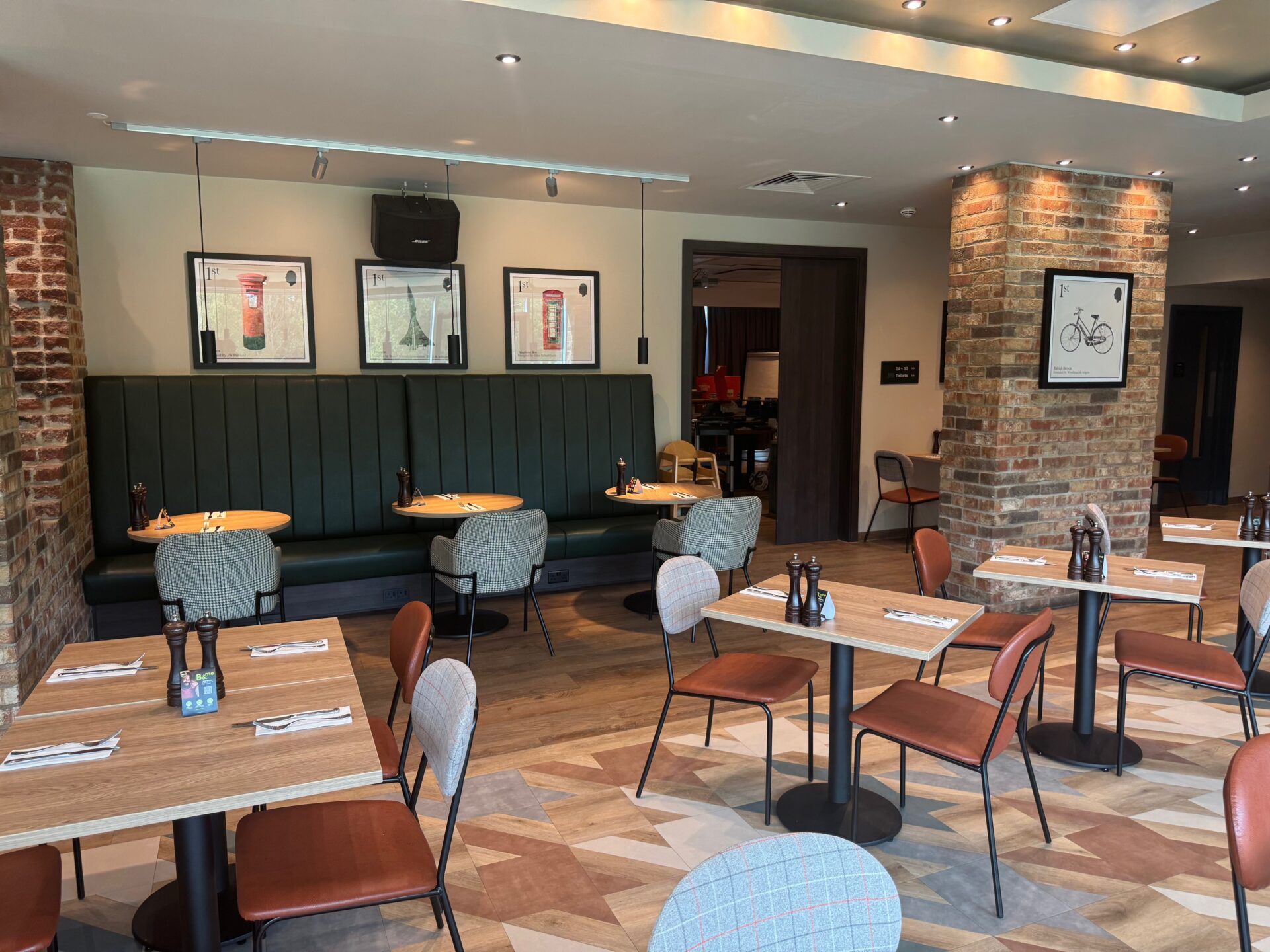 B&B Hotel Warrington B&B Hotel Warrington restaurant interior showcasing tables, chairs, and stylish decor with British-themed artwork.