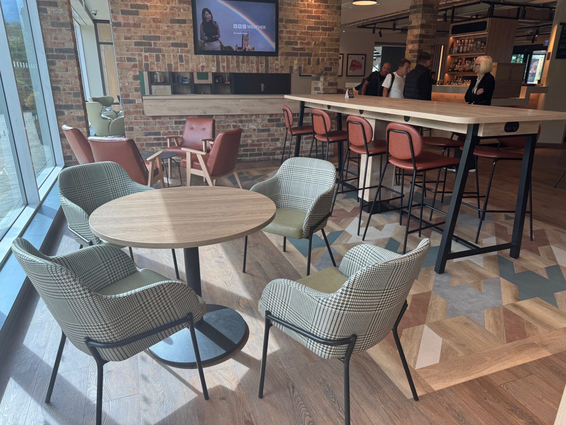 B&B Hotel Warrington lounge area with modern chairs, tables, and bar. Stylish interior design and comfortable seating.