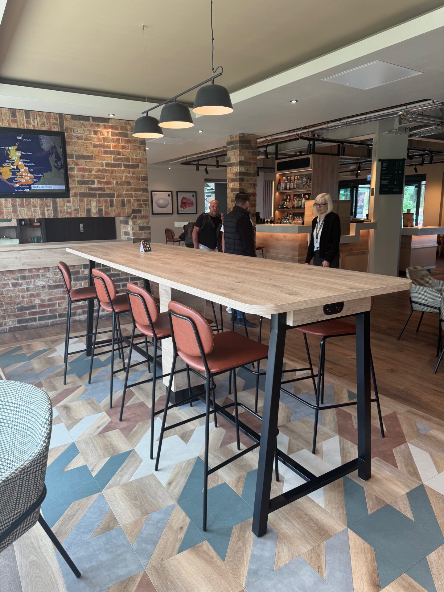 B&B Hotel Warrington B&B Hotel Warrington: Modern interior with high tables, chairs, stylish floor, and brick wall. Hotel dining area.