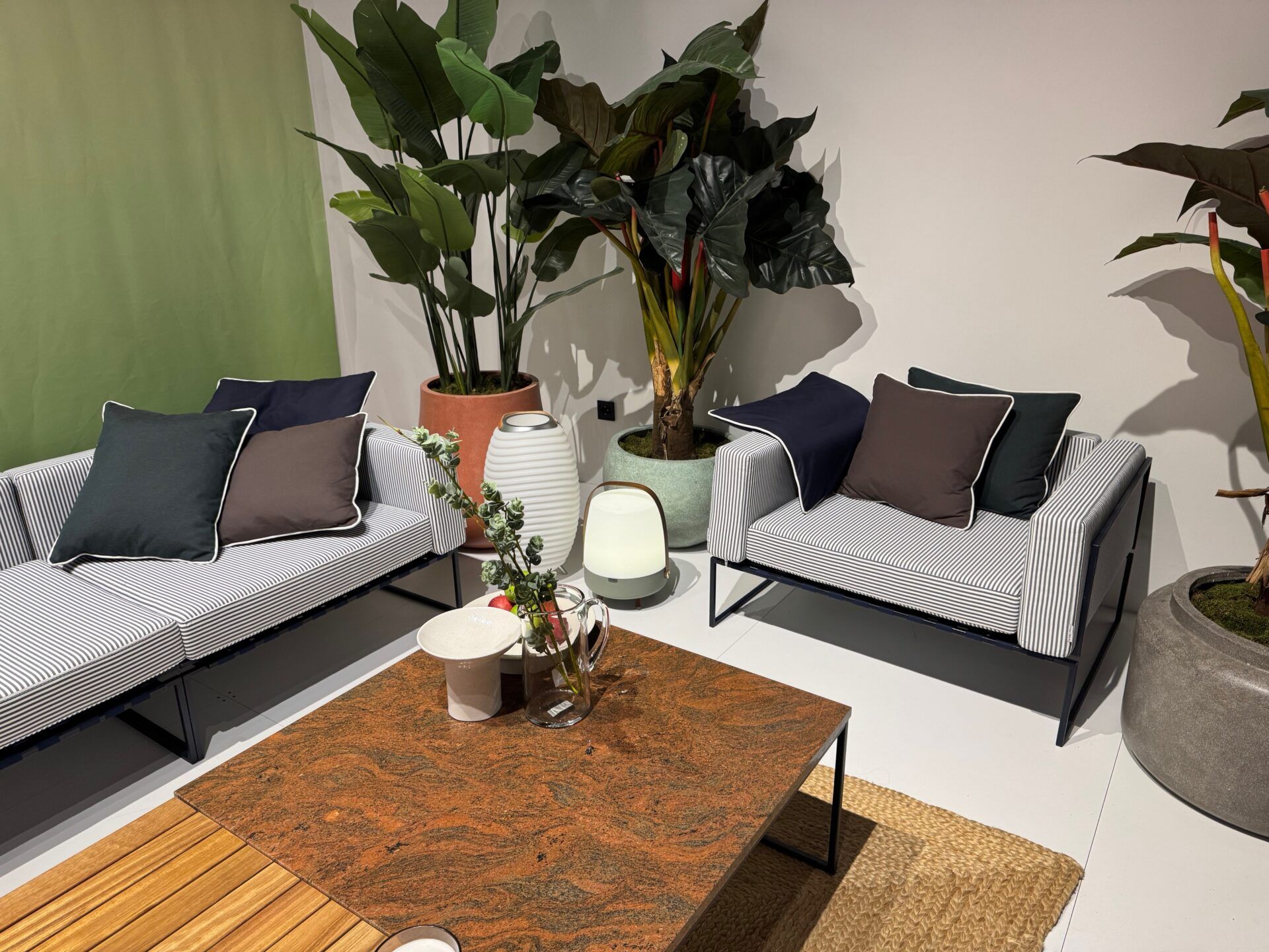 Istanbul Furniture Fair: Stylish striped sofa with accent pillows, unique lighting and plants, showcasing modern furniture design.