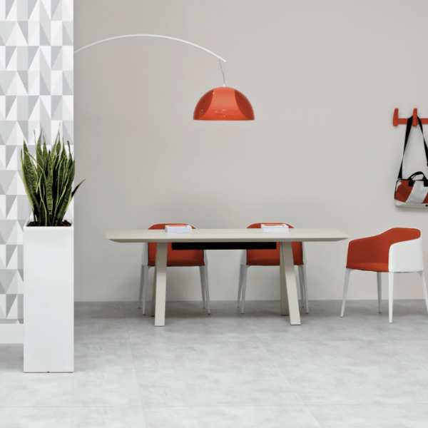 L002ST Floor Lamp with a metal base and orange lampshade, shown in a modern office setting with matching chairs and table.