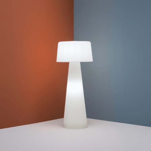 Minimalist Time Out Floor Lamp with a white shade and base, modern design against a blue and orange backdrop.