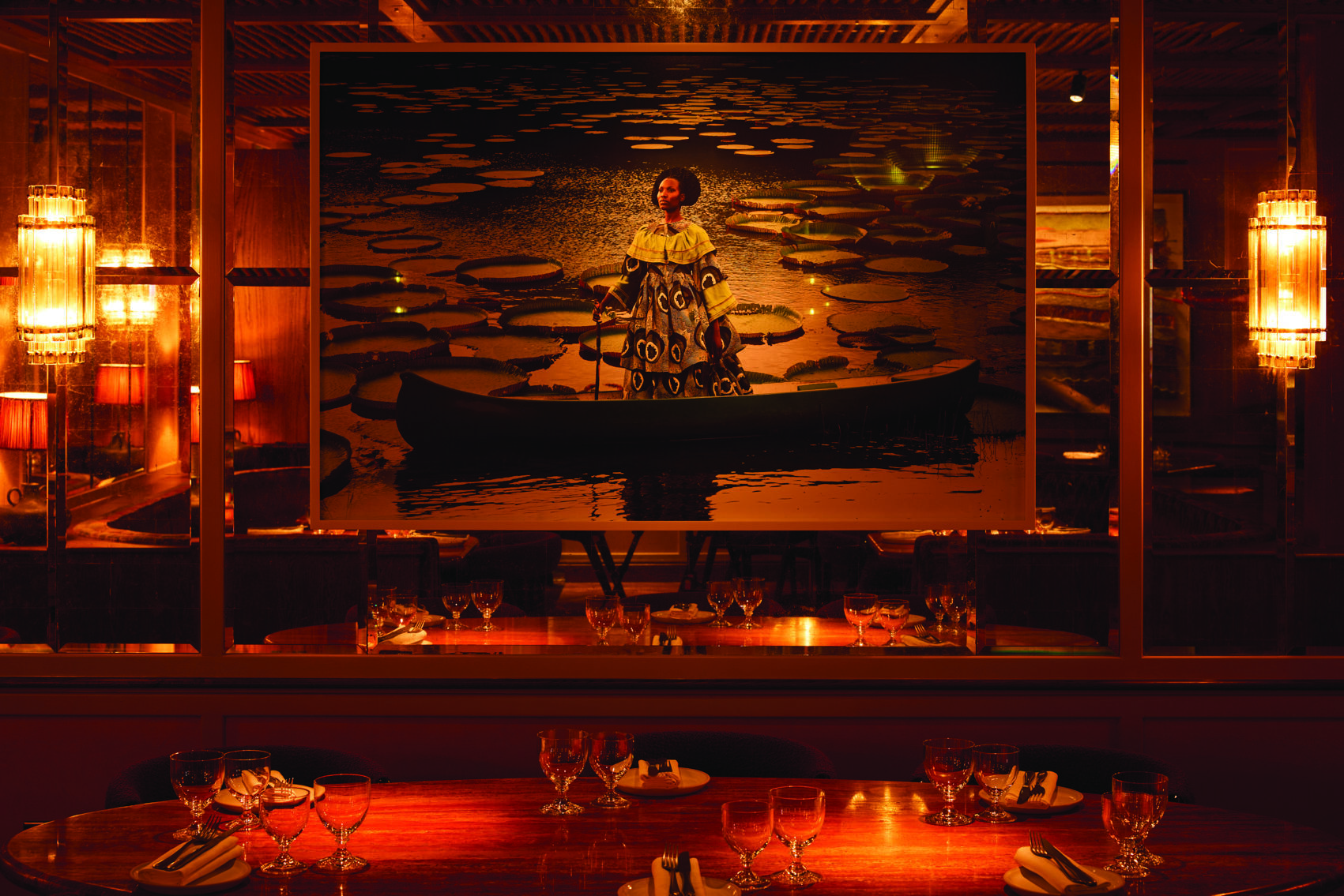 kudu restaurant Kudu Marylebone restaurant interior featuring an African woman in a boat artwork above a set dinner table.