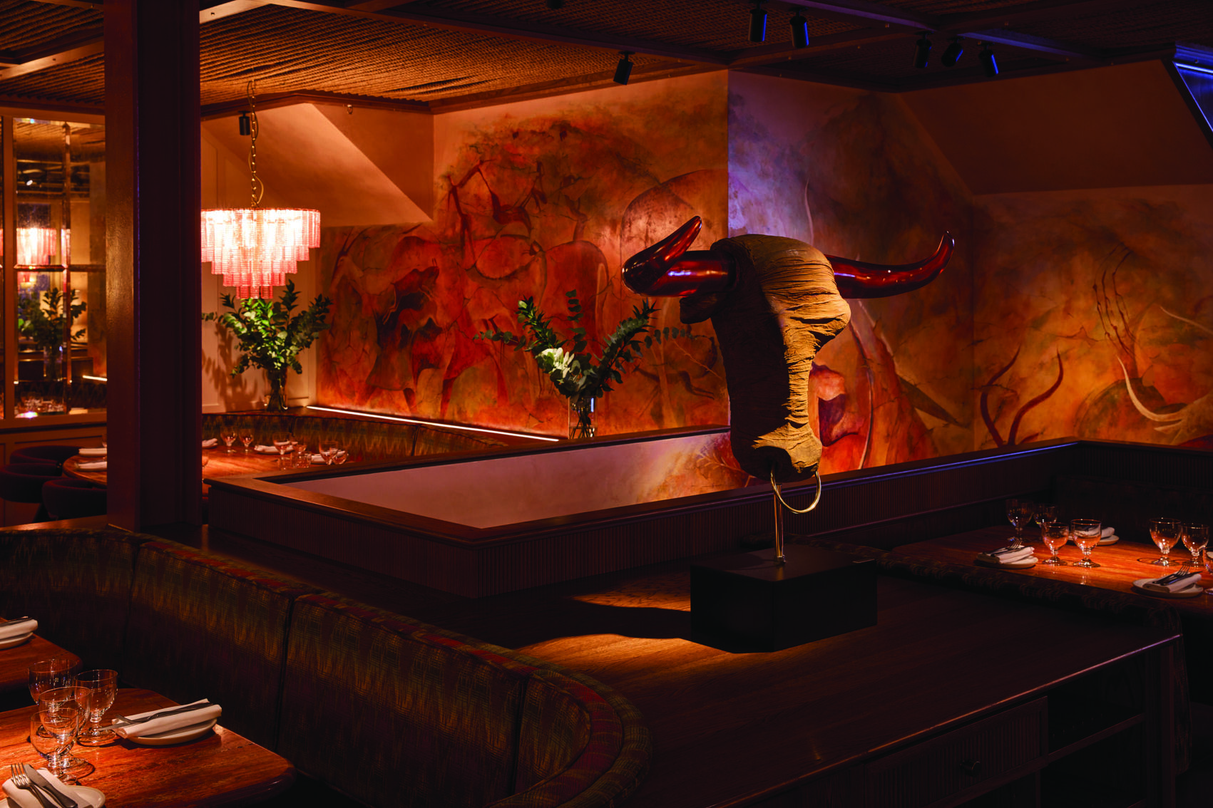 kudu restaurant Kudu Marylebone restaurant interior. Bull sculpture, warm lighting, and unique wall art create an inviting dining atmosphere.