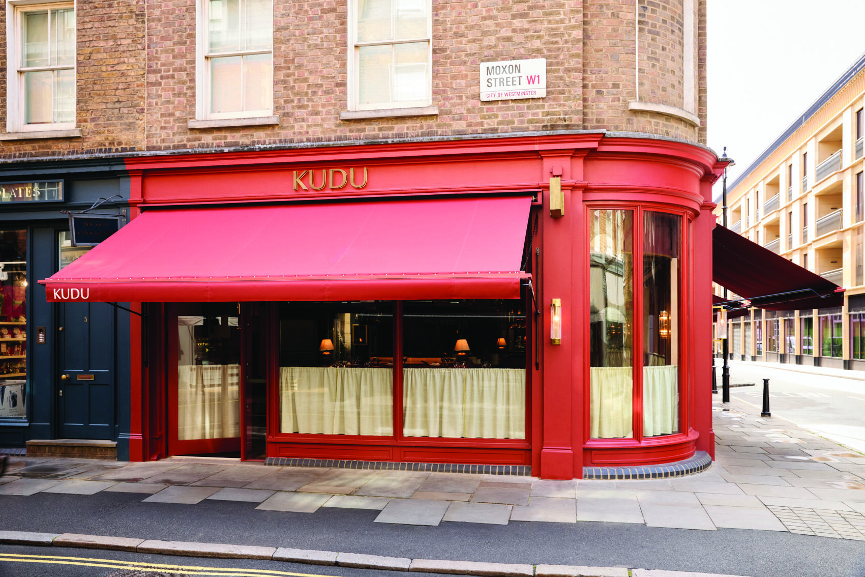 kudu restaurant Kudu Marylebone restaurant exterior. Red awning and facade on Moxon Street W1, brick building. Fine dining in London.