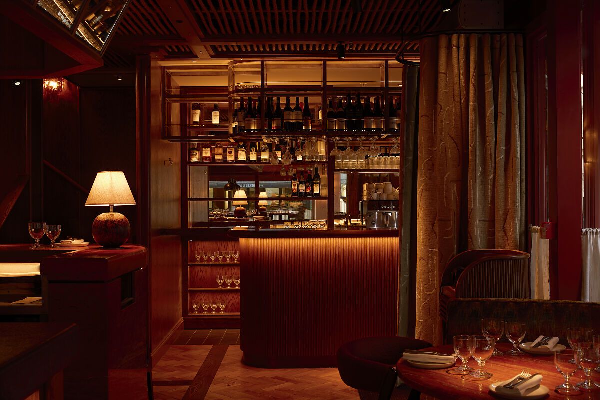kudu restaurant Kudu Marylebone restaurant interior with warm lighting, fully stocked bar, and set tables in a cozy ambiance.