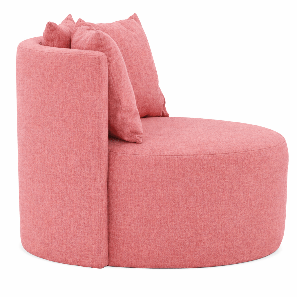 Angled view of the Queens Lounge Chair in pink fabric, featuring a rounded seat, curved back, and plush cushions.