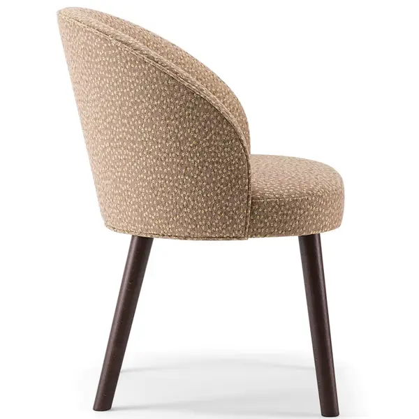 Side view of a Ginger 060 Armchair featuring a textured tan upholstered seat and back with dark wooden legs.