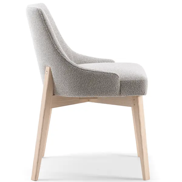 Side view of Kora Side Chair featuring light wood frame and textured grey upholstered seat and supportive backrest.