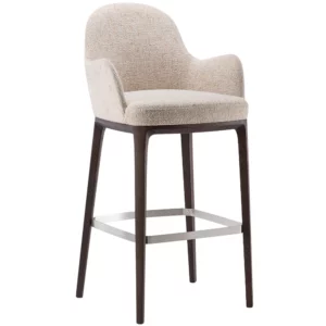 Angled view of the Olivia Barstool featuring upholstered seat and back in neutral fabric with a dark wood frame and metal footrest.