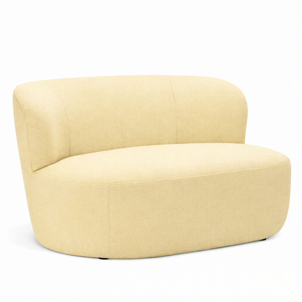 Angled view of a modern, upholstered Ted Sofa in light yellow fabric, featuring a curved back and rounded seat. Inviting design, contract furniture.