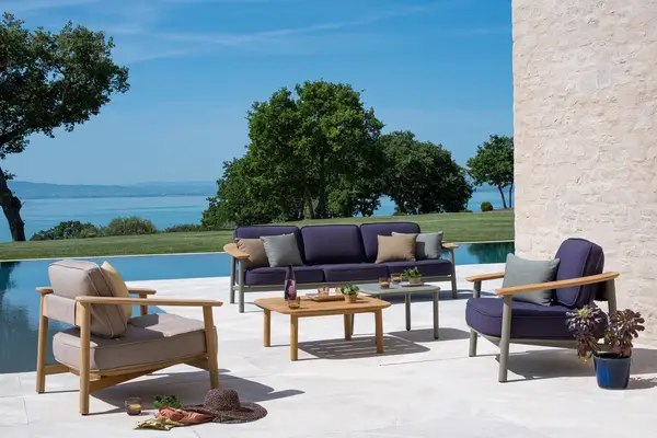 The Twins Sofa in an outdoor setting with upholstered cushions and metal frame, showcasing its elegance and suitability for outdoor spaces.