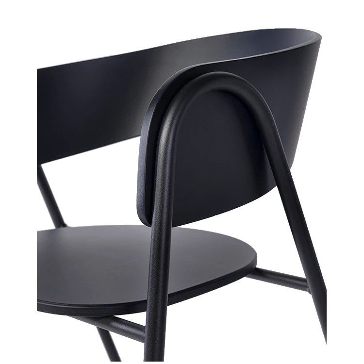 Close-up of the upholstered black Halley Armchair featuring a metal frame, rounded back and integrated arm design.