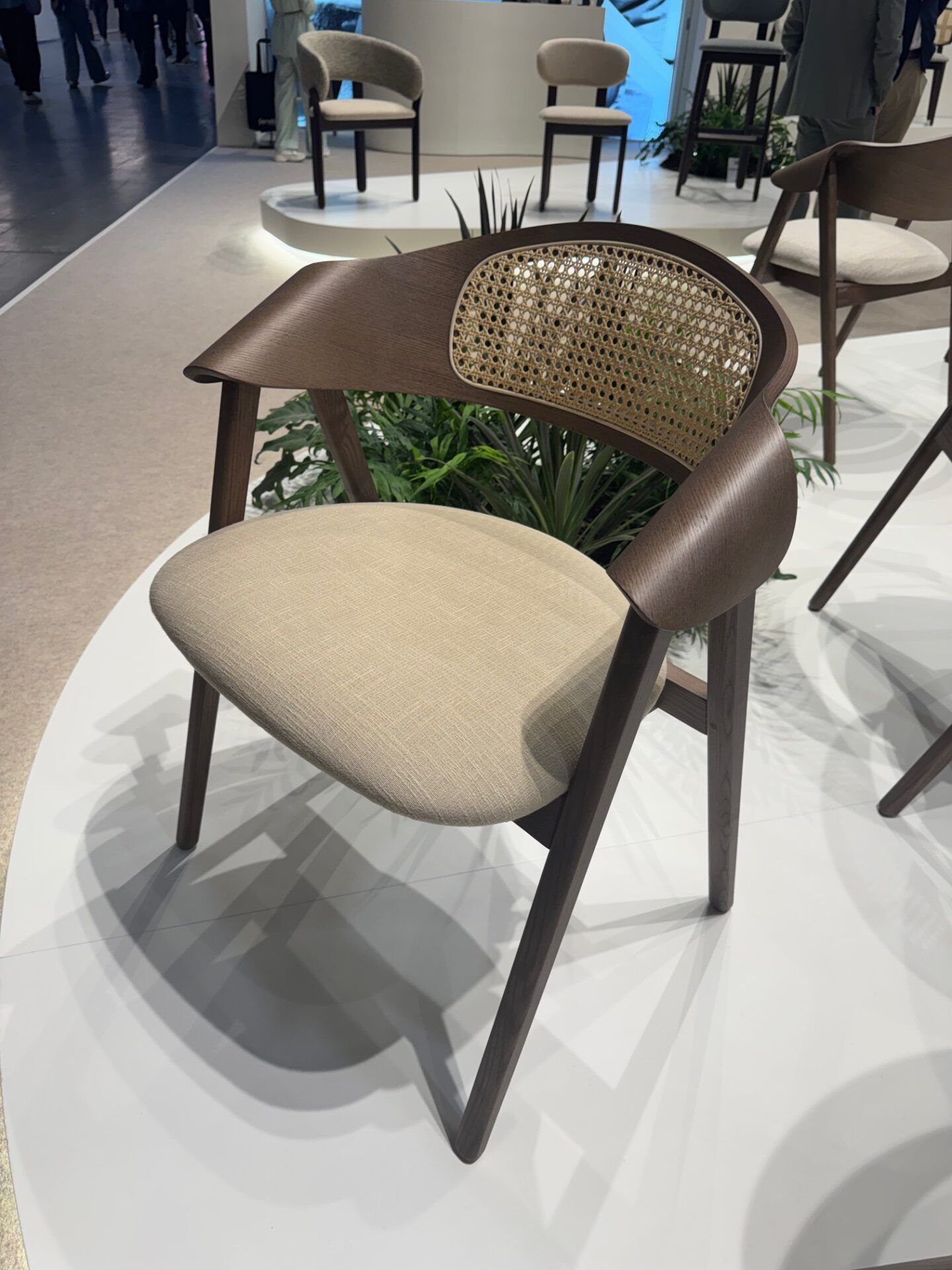Hospitality design: Modern wooden chair with woven back and neutral fabric seat at Salone del Mobile 2026 exhibit.
