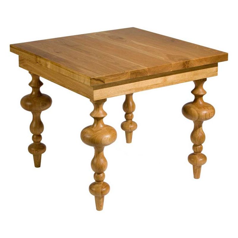 The Sonnet Dining Table shows a square, light oak top and ornately turned wooden legs.