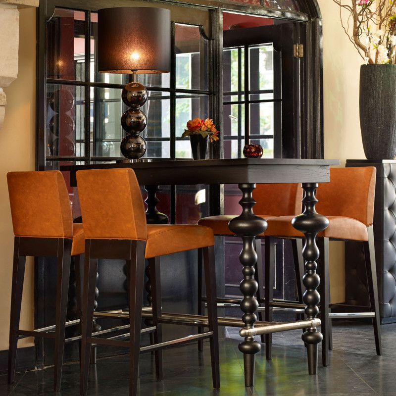 Pictured is the Marie Rectangle Poseur Table with accompanying chairs revealing the table's dark wood finish and pedestal base with metal footrest.